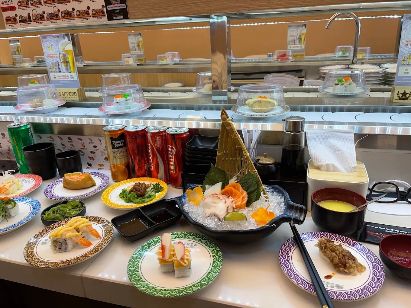 Các đĩa sushi và món ăn Nhật như sashimi, maki, salad rong biển, bánh xèo Nhật và chawanmushi (trứng hấp)
